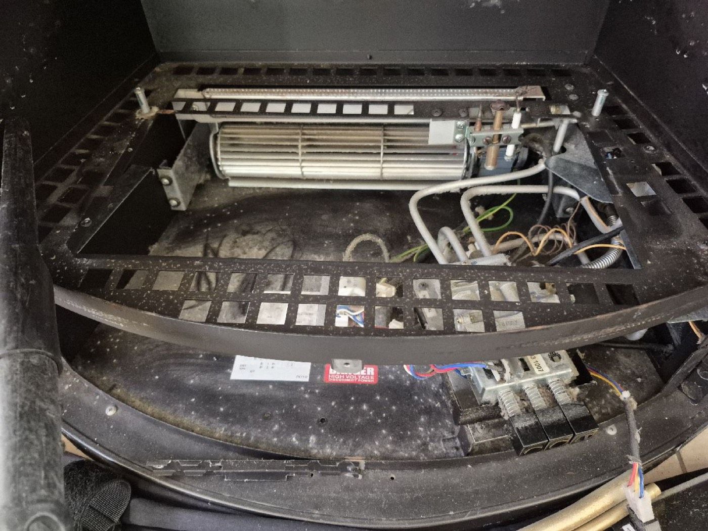 The burner tray of a gas fireplace during a service