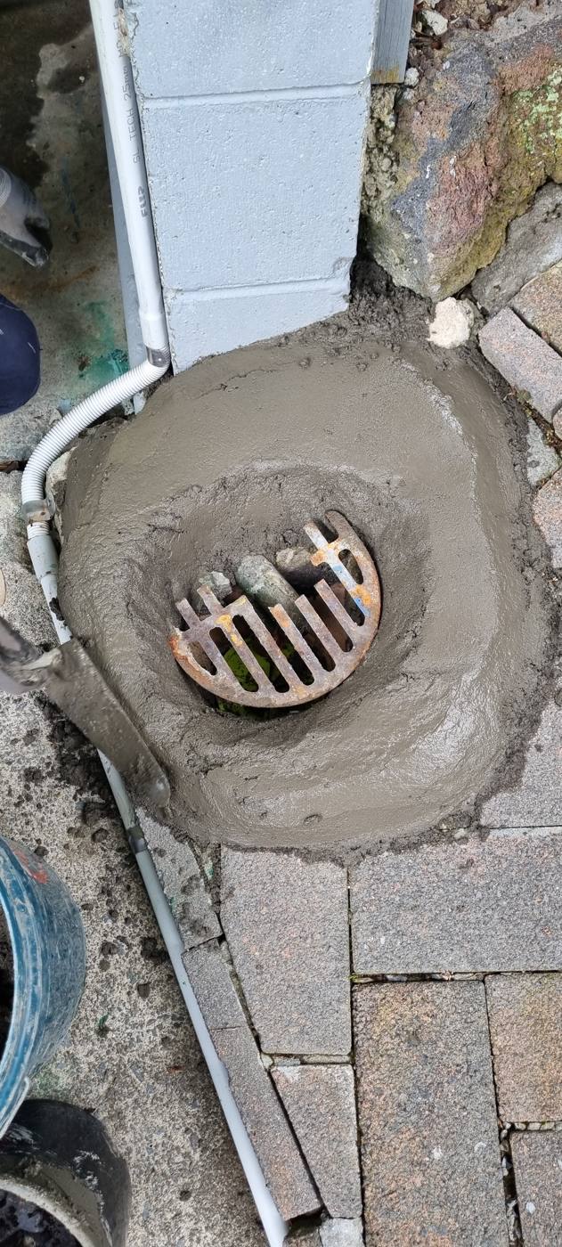 Gully trap raised with new concrete haunching and the downpipe separated from it