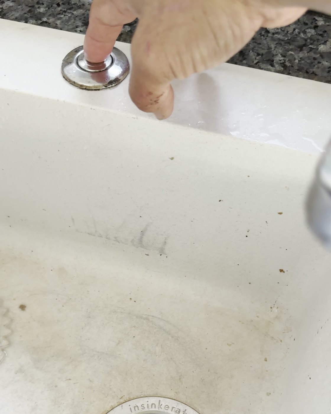 Air switch set into the sink beside an InSinkErator waste disposer flange in an Auckland kitchen