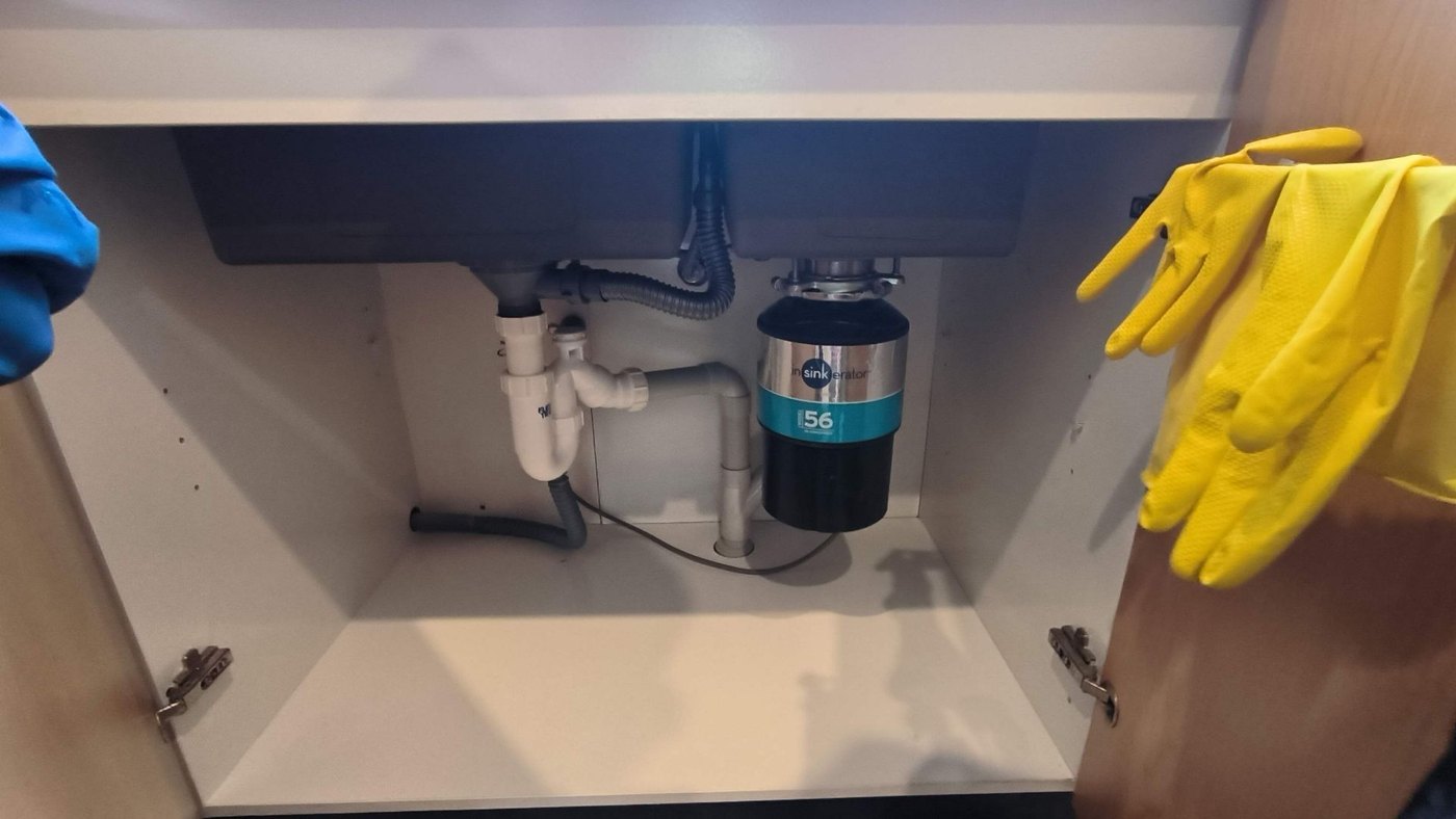 InSinkErator waste disposer installed under an Auckland kitchen sink beside the trap