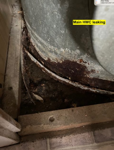 The corroded base of a leaking mains hot water cylinder